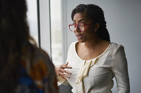 a woman sitting alone on a conference table at an office